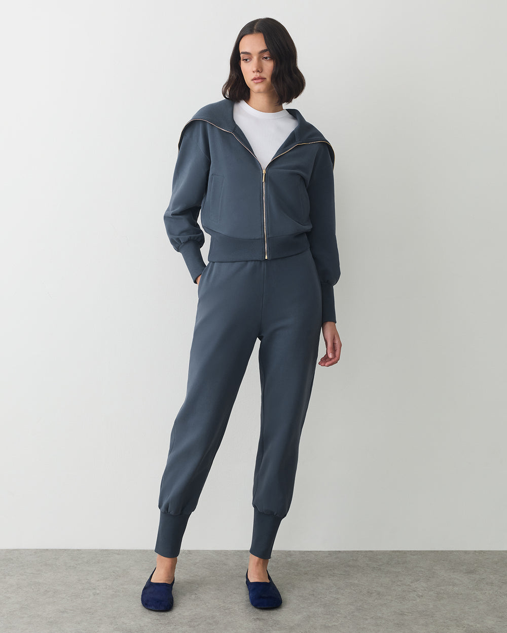 Fleece Oversized Collar Sweatshirt Person wearing a zip-up hoodie with matching joggers and slip-on shoes.