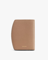 A textured passport holder with a curved edge on a plain background.