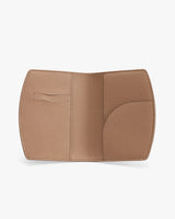 Open wallet with card slots and curved pocket on flat surface.