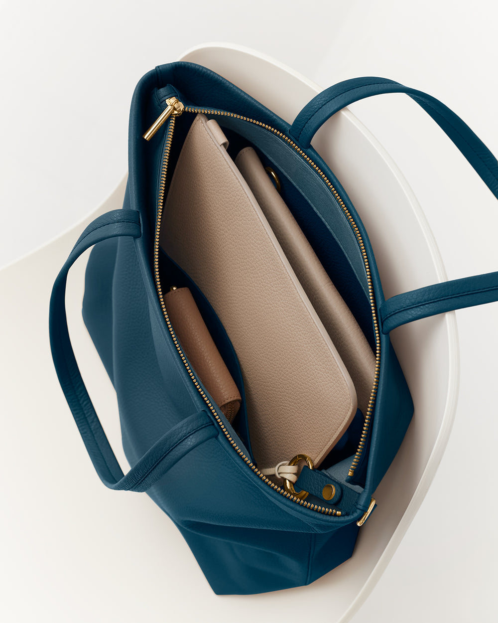 Tall Easy Zipper Tote Open travel bag with items inside on a chair.