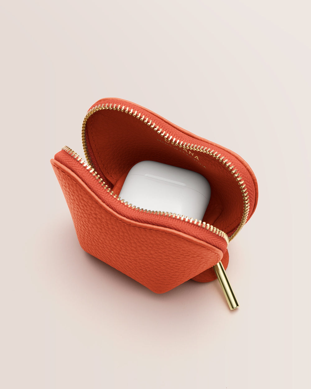 Tiny Heart Case Small zippered pouch with white earbuds inside.