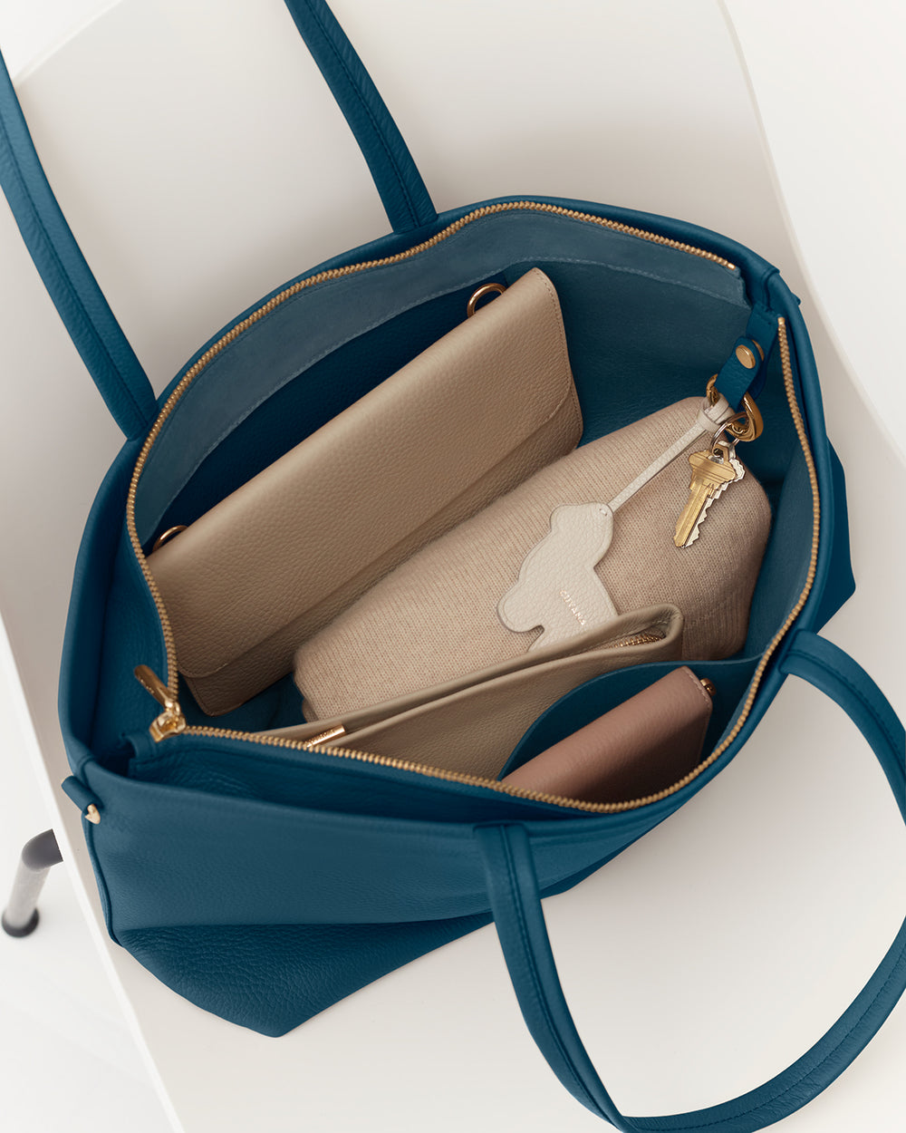 Small Easy Zipper Tote Open travel bag containing two wallets, a notebook, and a set of keys.