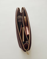Open makeup bag with brushes and cosmetics inside