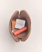 Open makeup pouch with three cosmetics inside.