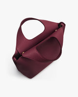 Handbag with circular cutout handle viewed from top angle.