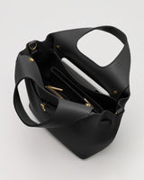 Open purse with contents visible including a tablet and pockets.