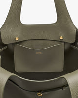 Open handbag with textured finish and interior pocket with gold accents.