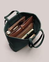 Open tote bag with organized items inside, including wallets and a phone.
