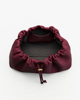 Open drawstring bag with visible interior pocket and gold clasp.