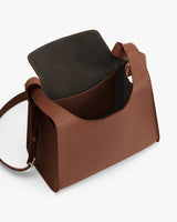 Open leather handbag with wide strap and visible main compartment.
