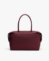 Handbag with two handles and flap closure on white background