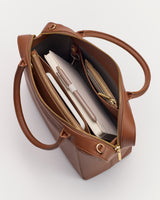 Open tote bag with a notebook, pen, and zippered pouch inside.