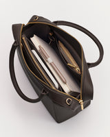 Open handbag with visible contents including a notebook, pen, and wallet.