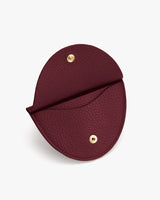 Round coin purse with snap buttons and textured surface.