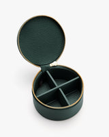 Round jewelry case with zipper and four compartments.