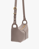 Shoulder bag with adjustable strap and small zip pocket.