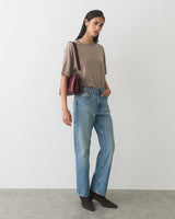 Person in casual outfit carrying a handbag.