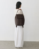 Person standing with a large bag over shoulder, back facing the camera.