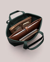 Open tote bag with organized compartments holding notebooks and pouches.