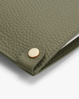 Close-up of a textured leather cover with a metal button stud.