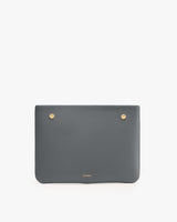 Rectangular clutch with two round metal studs on the top corners.