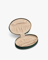 Oval jewelry case with zipper, open to show ring and earring slots inside.