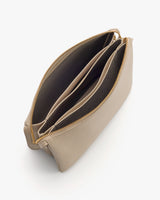 Open handbag with three compartments and gold zipper.