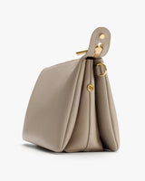 Side view of a structured handbag with gold accents