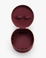 Round open jewelry case with elastic slots inside.