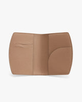 Open, textured rectangular passport cover with card slot on left and curved pocket on right.