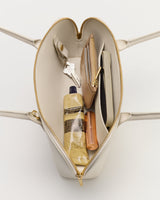 Open handbag showing keys, wallet, phone, lotion, and lipstick inside.
