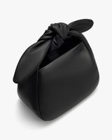 Handbag with a knotted handle and open compartment