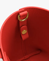 Close-up of handbag interior with a gold clasp and snap button.