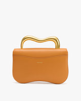 Handbag with wavy handle on white background.