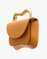 Curved handbag with abstract handle design