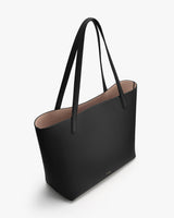 Large tote bag with long straps on a plain background
