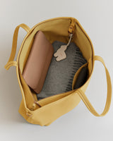 Open bag with a wallet and gray fabric inside.