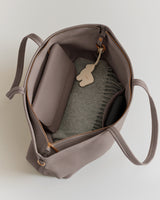 Top view of an open travel bag with items inside.