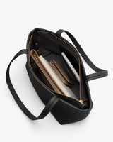 Open tote bag with visible contents including a tablet and pouches.