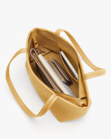 Open tote bag with items organized inside, including a notebook and a wallet.