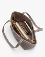 Open handbag with zipper showing items inside.