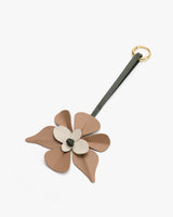 Flower-shaped leather keychain with loop attachment.
