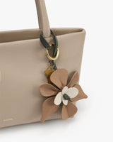 Tote bag with floral keychain attached to handle.