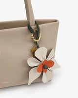 Tote bag with a floral keychain attached to the handle.