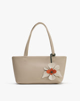 Handbag with flower detail on the front and two handles.