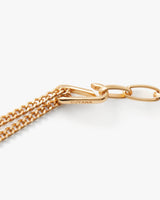 Close-up of a chain necklace with a clasp labeled Cuyana.