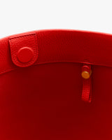 Open tote bag with a round button and a strap inside.