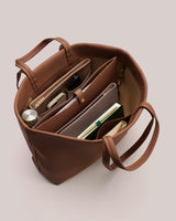 Open tote bag with organized items inside, including a notebook, phone, and water bottle.