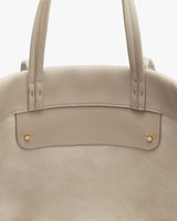 Tote bag with two handles and metal rivets.