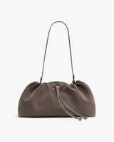 A gathered handbag with a drawstring and thin shoulder strap.